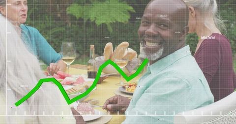 Smiling senior man at alfresco table with green upward chart suggesting healthy lifestyle