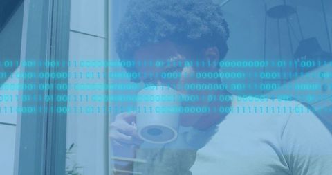 Sipping coffee looking out window with binary code overlay, remote work morning calm