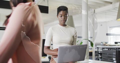 Focused Professional Typing on Laptop in Modern Office Environment