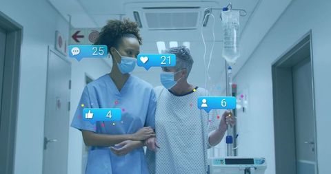 Compassionate nurse supporting patient walking with iv pole in hospital corridor