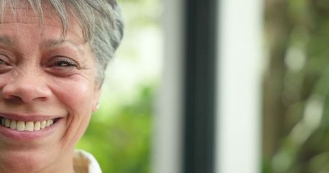 Senior Woman Smiling Warmly Next to Window