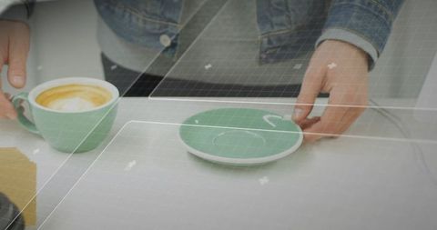 Barista arranging saucer with modern tech grid background