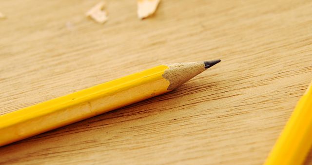 Close-up of freshly sharpened yellow pencil on wooden surface - Download Free Stock Images Pikwizard.com