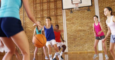 Energetic Teenagers Playing Basketball in School Gym