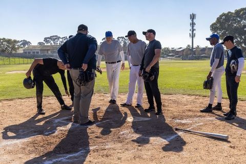 Diverse Baseball Players and Umpire Gathering at Home Plate on Sunny Diamond Before Game