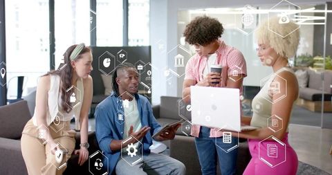 Collaborating multicultural startup team brainstorming with laptop and tablet in modern office