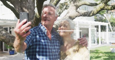 Vivacious Older Couple Taking Selfie in Sunlit Back Garden