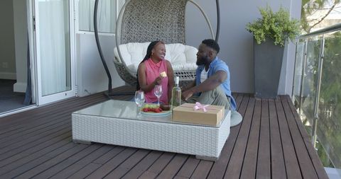 Romantic balcony gift exchange with refreshments