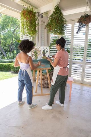Mother and Daughter Bonding Through Art Painting Outdoors on Patio