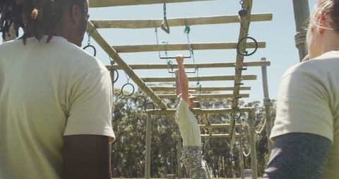 Military trainer leading diverse soldier group on obstacle course