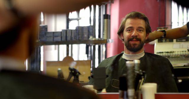 Caucasian man getting a haircut at a barbershop. Smiling in the mirror, he enjoys a grooming session in the vibrant salon setting.