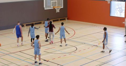 Group of Basketball Players Practicing on Indoor Court