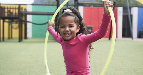 Joyful African American Girl Playing with Hula Hoop in Playground