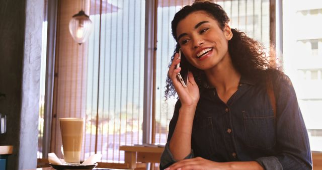 African American woman smiling talking on phone in café with coffee - Download Free Stock Images Pikwizard.com