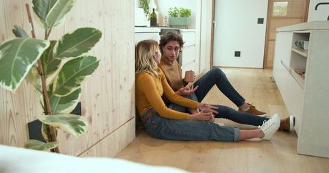 Couple Relaxing on Wood Floor in Bright Minimalist Kitchen