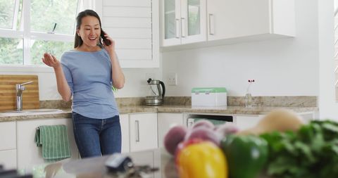 Happy Asian Woman Talking on Smartphone in Modern Kitchen - Download Free Stock Images Pikwizard.com