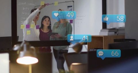 Business team brainstorming on glass wall with sticky notes and tablet, social metrics
