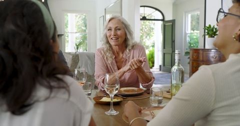 Joyful Gathering with Food and Wine in Well-Lit Living Space