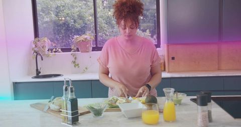 Preparing healthy breakfast chopping avocado and eggs on modern minimalist kitchen island