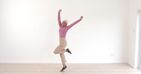 Energetic Woman Dancing in Minimalist Living Room