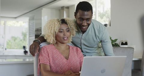 Happy African American Couple Engaging with Laptop in Home