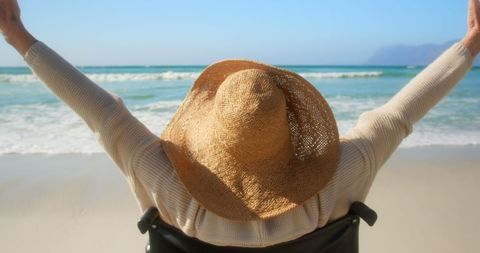 Senior Woman Enjoying Beachtime in Wheelchair with Arms Outstretched - Download Free Stock Images Pikwizard.com
