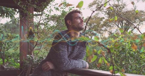 Contemplative man on porch with digital audio waveform overlay