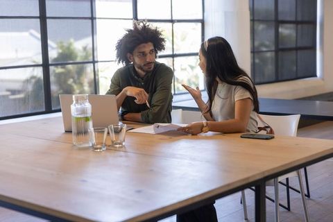 Coworkers Discussing Ideas in Bright Modern Office Environment
