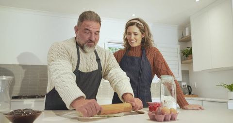 Joyful Couple Flattening Dough Together in Bright Rustic Kitchen