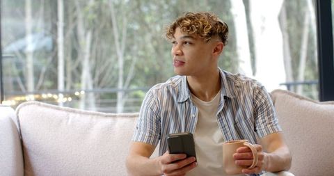 Relaxed Man Enjoying Coffee and Technology in Modern Home