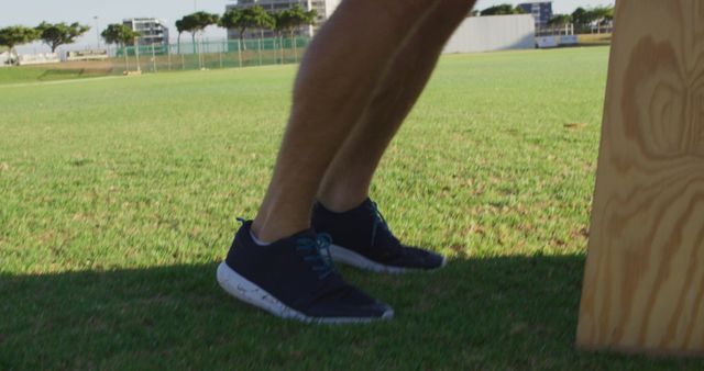 Person stretching legs outdoors on grass field - Download Free Stock Images Pikwizard.com