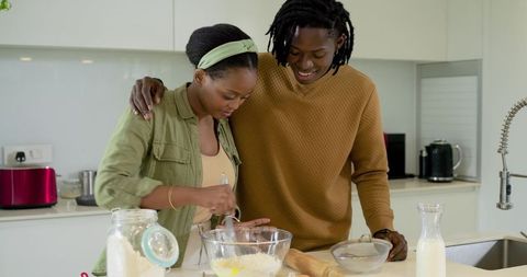 Smiling African American Couple Mixing Batter on Bright Modern Kitchen Island
