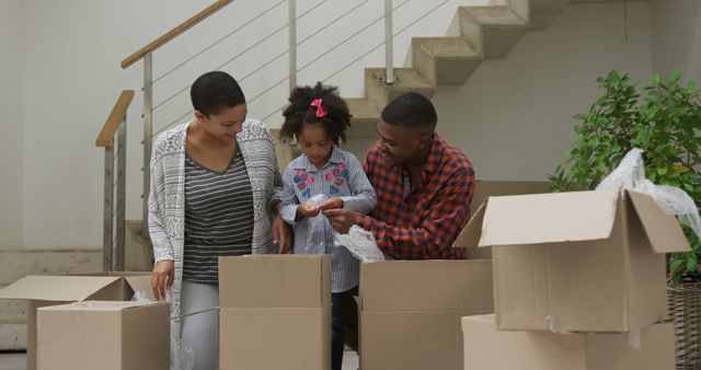 Happy Family Moving into New Home Unpacking Boxes Together - Download Free Stock Images Pikwizard.com