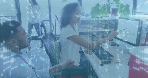 Pointing woman analyzing financial charts on open-plan office monitor with digital overlay