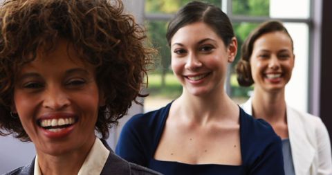 Diverse professional women smiling in workplace setting