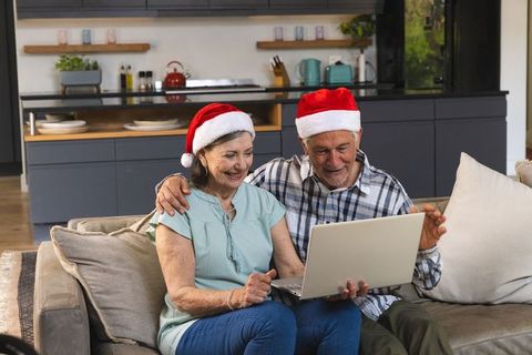 Happy Senior Couple Using Laptop at Home During Christmas Season