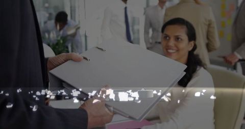 Woman Accepting Files in Team-Oriented Office Environment