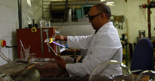 Man Blowing Glass in Factory Workshop with Tablet Assistance - Download Free Stock Images Pikwizard.com