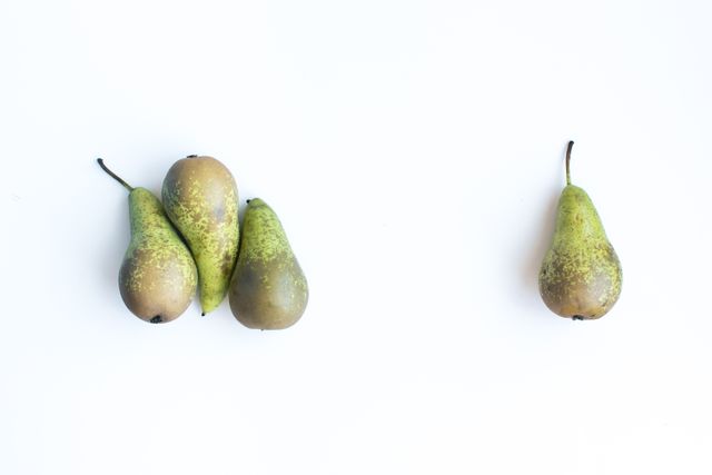 Four pears clustered together beside single isolated pear on white background - Download Free Stock Photos Pikwizard.com