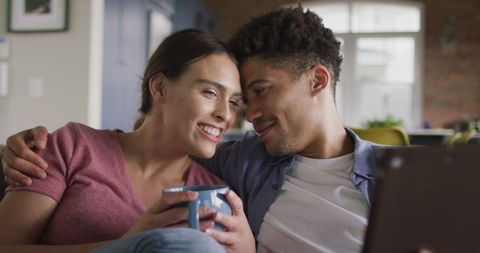 Happy Couple Relaxing with Laptop and Coffee at Home