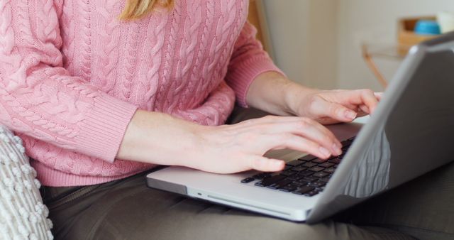 Woman Typing on Laptop at Home in Pink Sweater - Download Free Stock Images Pikwizard.com