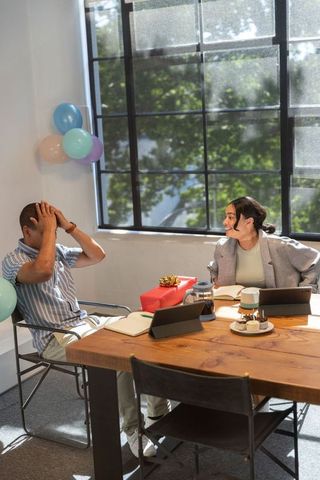 Surprised Coworkers Celebrating with Gift and Balloons in Office