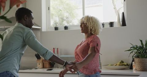Man Proposing to Surprised Woman in Modern Kitchen Setting