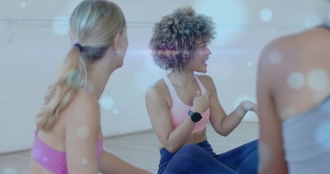Leading group fitness class in bright studio, female instructor gesturing with smartwatch