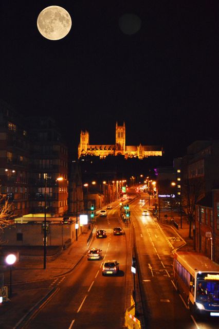 City Street at Night with Full Moon and Illuminated Cathedral - Download Free Stock Photos Pikwizard.com