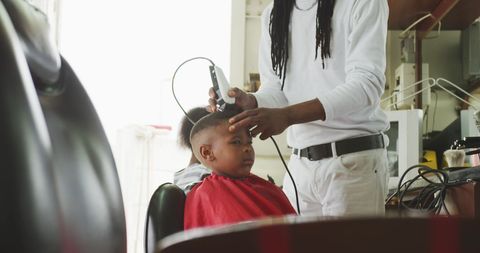 Barber Giving Haircut to Young Boy in Salon - Download Free Stock Images Pikwizard.com