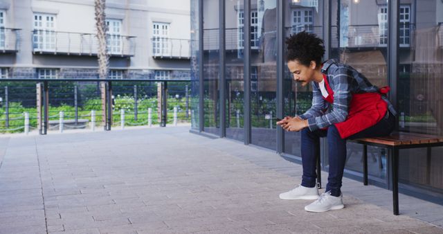 Young Man in Red Apron Checking Smartphone Outdoors - Download Free Stock Images Pikwizard.com