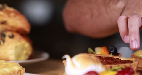 Person Reaching for Delicious Breakfast Pastries on Dining Table - Download Free Stock Images Pikwizard.com