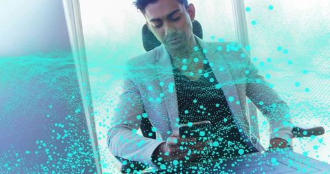Indian executive checking phone by window with holographic turquoise data overlay