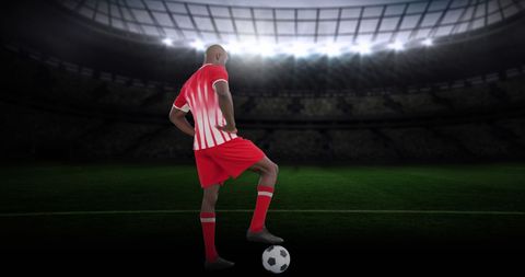 Football Player Stands Poised Under Stadium Lights